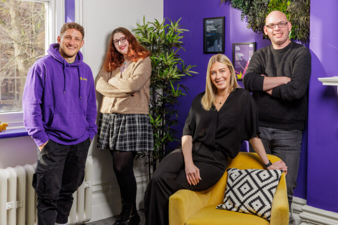 Moxie team posing around the laptop