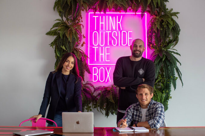 2 person standing and 1 person sitting